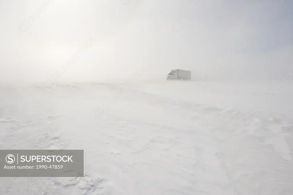 Truck on road covered with blowing snow, near Morris, Manitoba, Canada