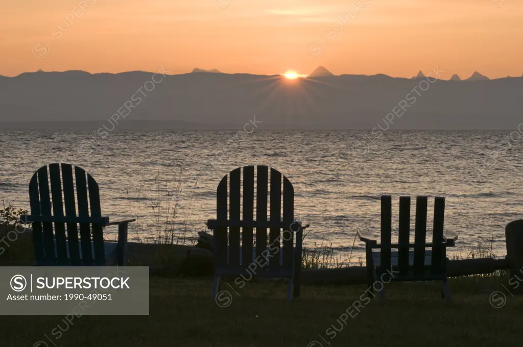 Adirondack chairs lined up on the beach at sunrise. Merville, British Columbia, Canada