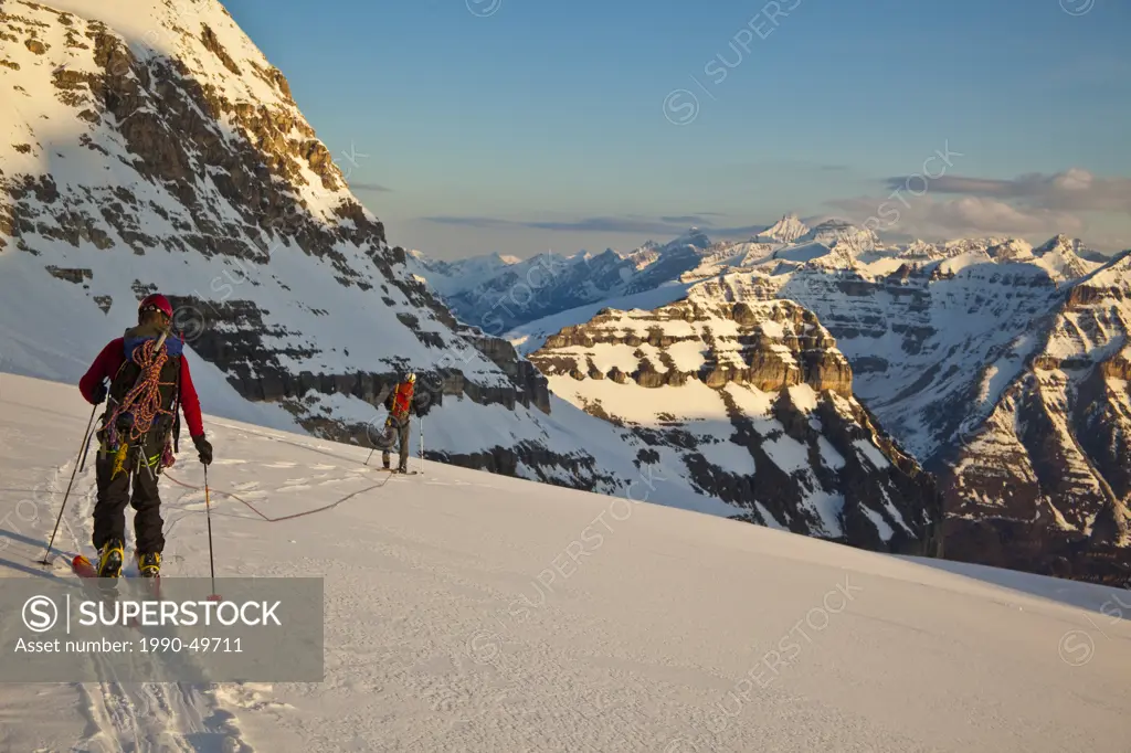 Two male backcountry skiers head across a glacier to ski the North Face of Mt. Stanley , Kootenay National Park, British Columbia, Canada