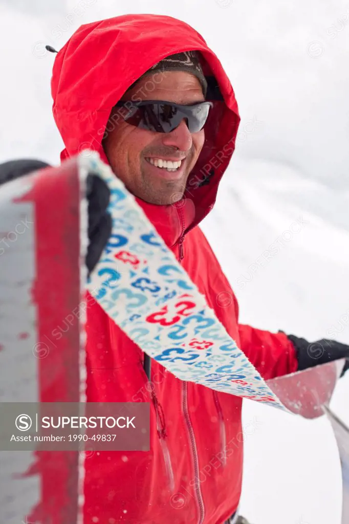 a mountain guide pulls the skins off his skis. Icefall Lodge, Golden, British Columbia, Canada