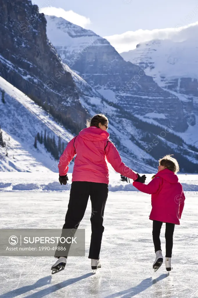 Mother and daughter ice skating at Lake Louise, Banff National Park, Alberta, Canada.