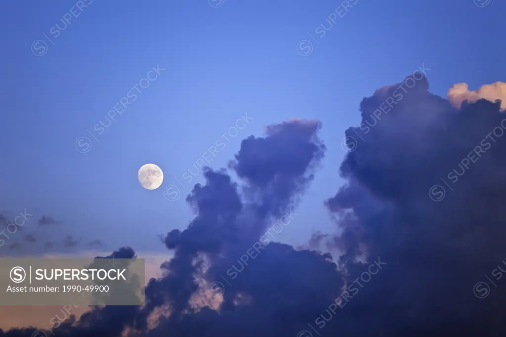 Full moon at dusk and clouds dissipating, Winnipeg, Manitoba, Canada.