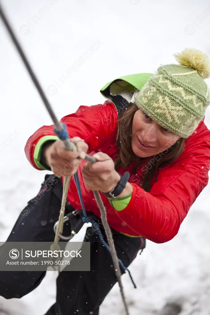A woman practicing glacier self rescue while on a ski mountain eeering course at Icefall Lodge, Golden, British Columbia, Canada
