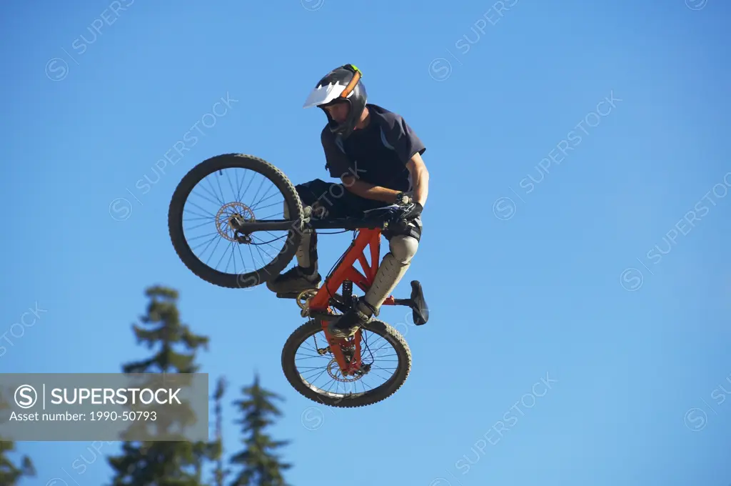 Mountain biker pulling a jump in Whistler Village Mountain Bike Park, British Colunbia, Canada.