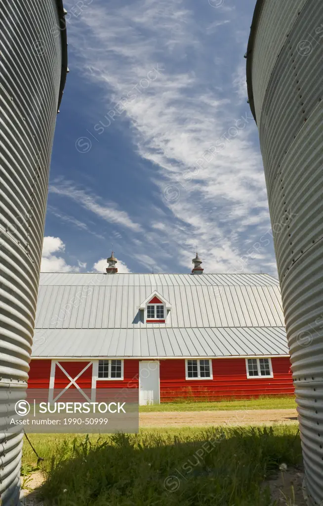 closeup of grain bins with red barn in the background near Torquay, Saskatchewan, Canada