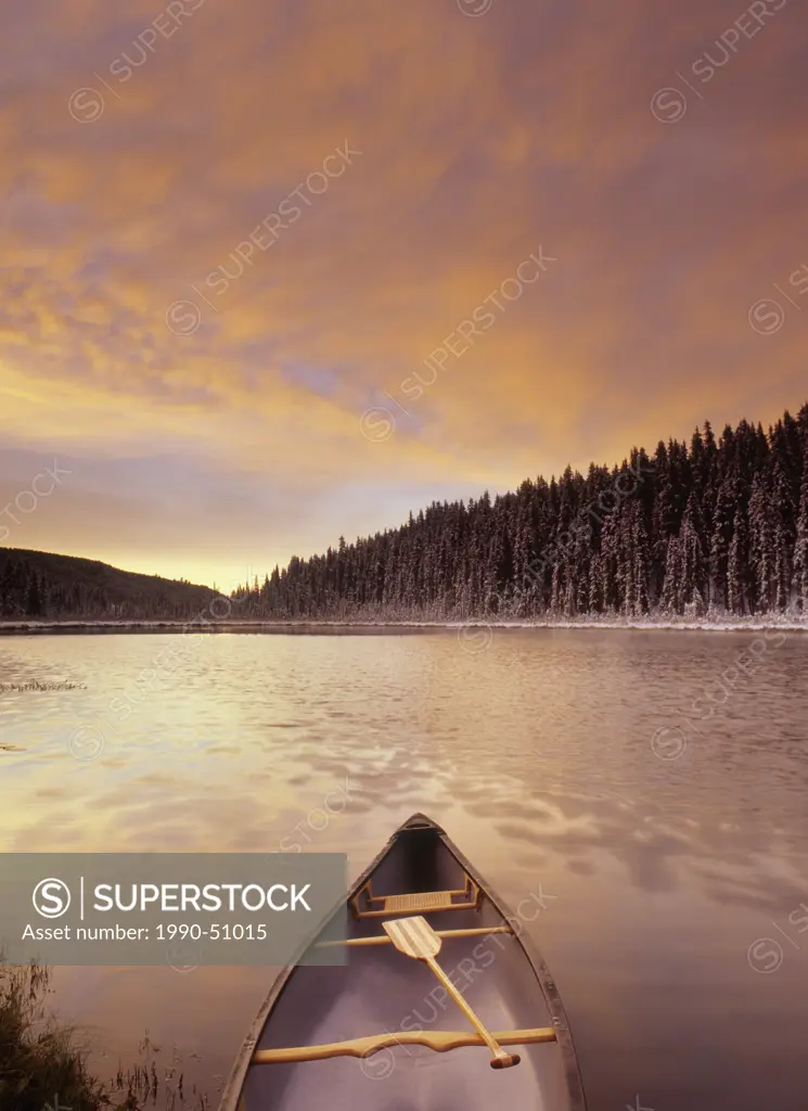 Canoe on Boggy Lake at sunset, Alberta, Canada.