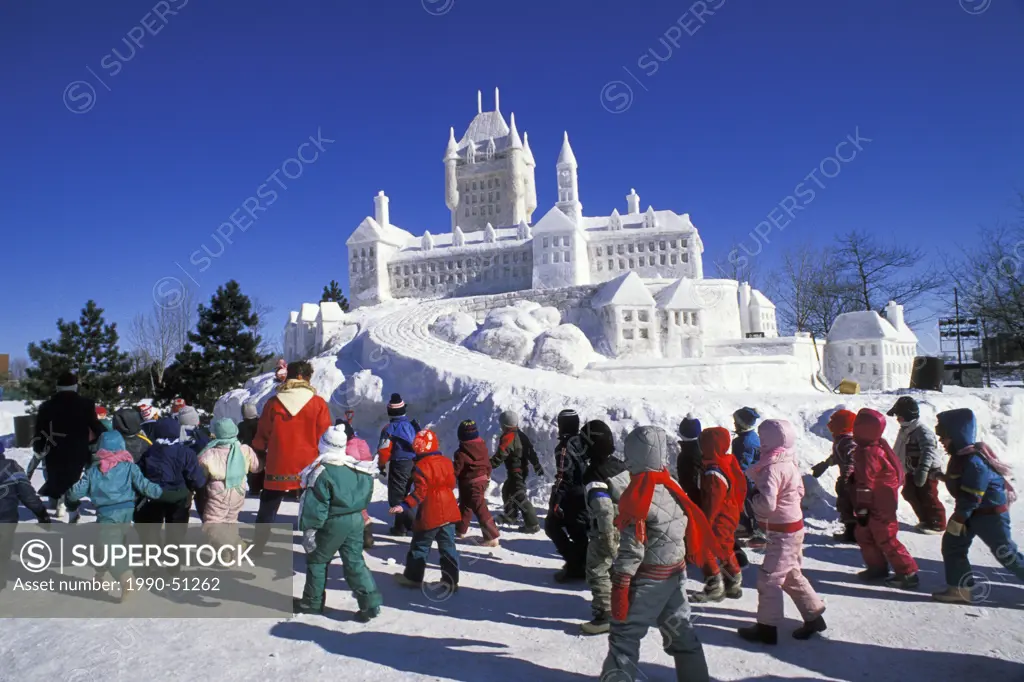 Children looking at snow sculpture at Winterlude Festival, Jacques Cartier Park, Hull Gatineau, Quebec, Canada. Winterlude is an annual festival held ...