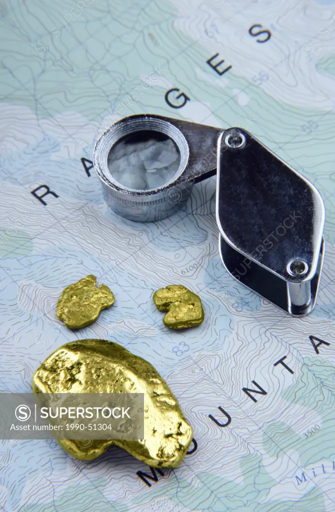 Mining exploration concept with nuggets, map, and magnifier, British Columbia, Canada.