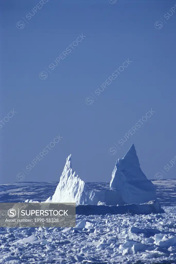 Iceberg embedded in pack ice near Boat Harbour Great Northern Peninsula, Strait of Belle Isle Newfoundland and Labrador, Canada.