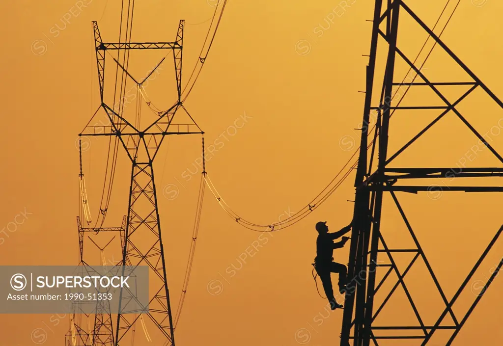 A worker climbs an electrical tower, Manitoba, Canada