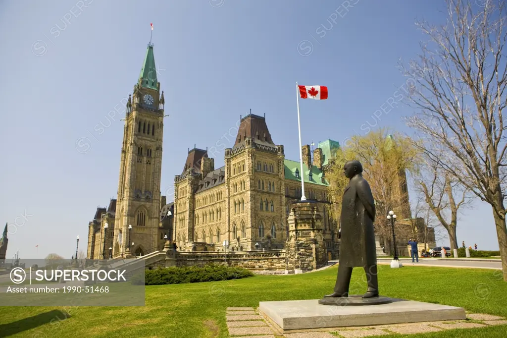 Statue of William Lyon Mackenzie King 1874_1950 in the grounds of Parliament Hill backdropped by the Centre Block, City of Ottawa, Ontario, Canada.
