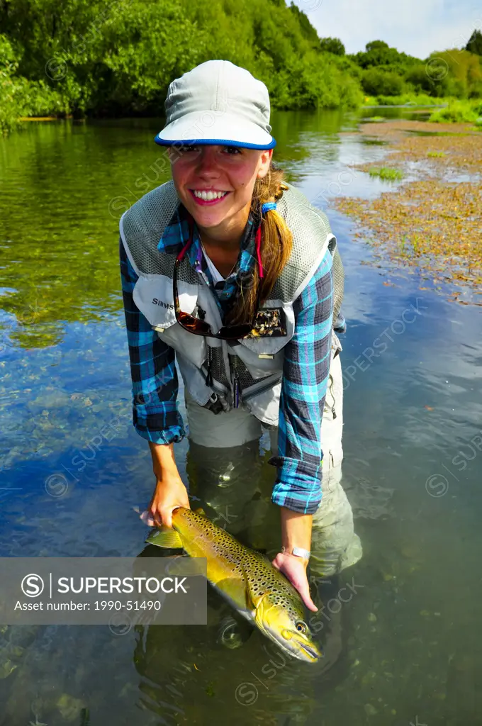 Woman holding rainbow trout, New Zealand