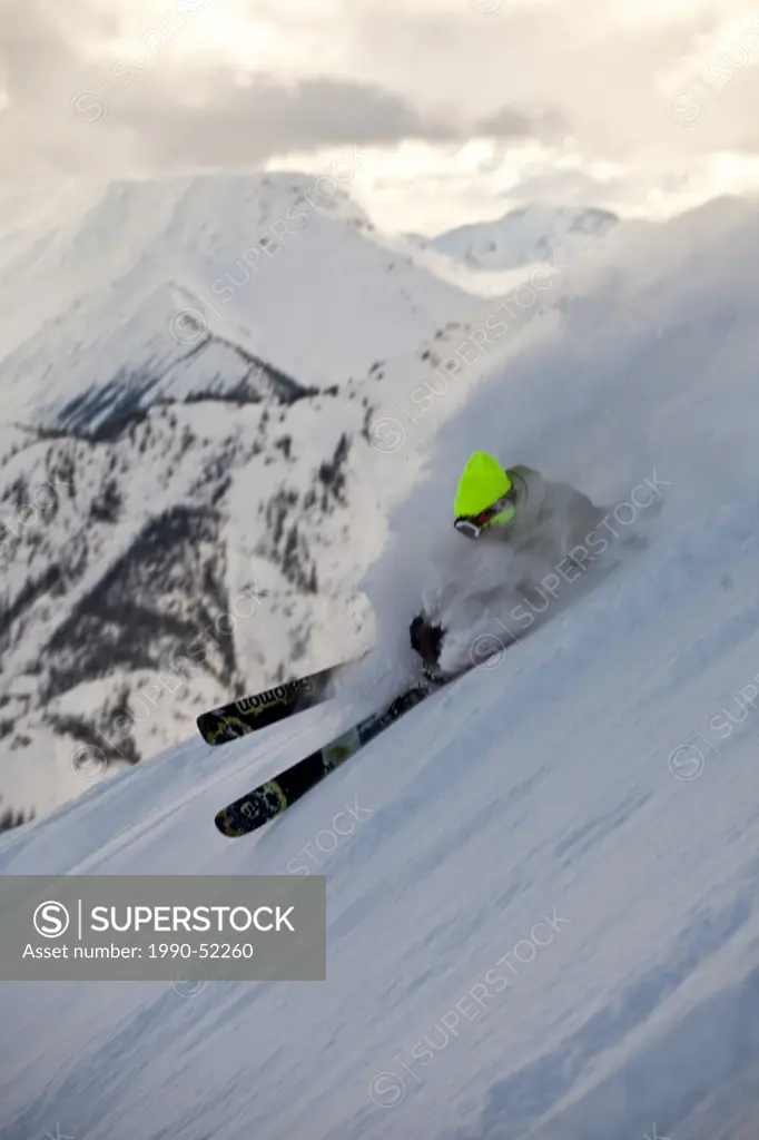 A young male skier slashes a powder turn just out of bounds at Kicking Horse Resort, Golden, Britsh Columbia, Canada