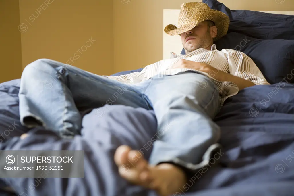 A man in a cowboy hat taking a nap, British Columbia, Canada.