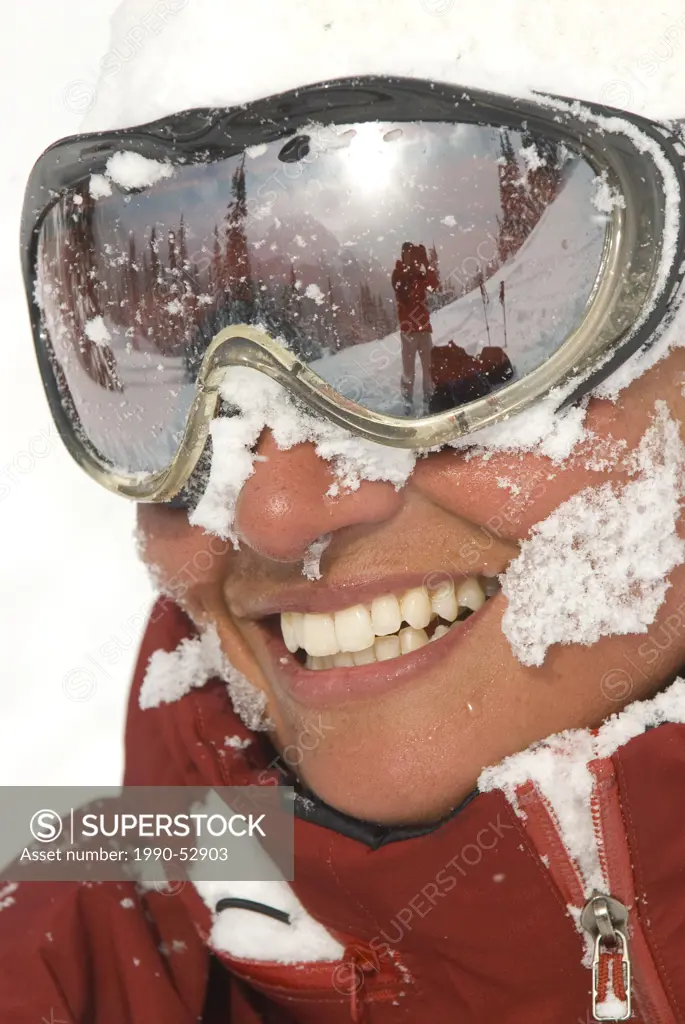 A skier laughs at her fortune after receiving a face full of snow while skiing in the Coast Mountains at MacGillivray Pass, British Columbia, Canada.