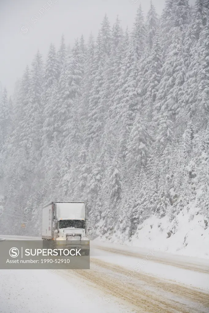 A transport truck driver negotiates treacherous winter driving conditions in a snowstorm along the Trans Canada Highway Highway 1 in Rogers Pass, Glac...