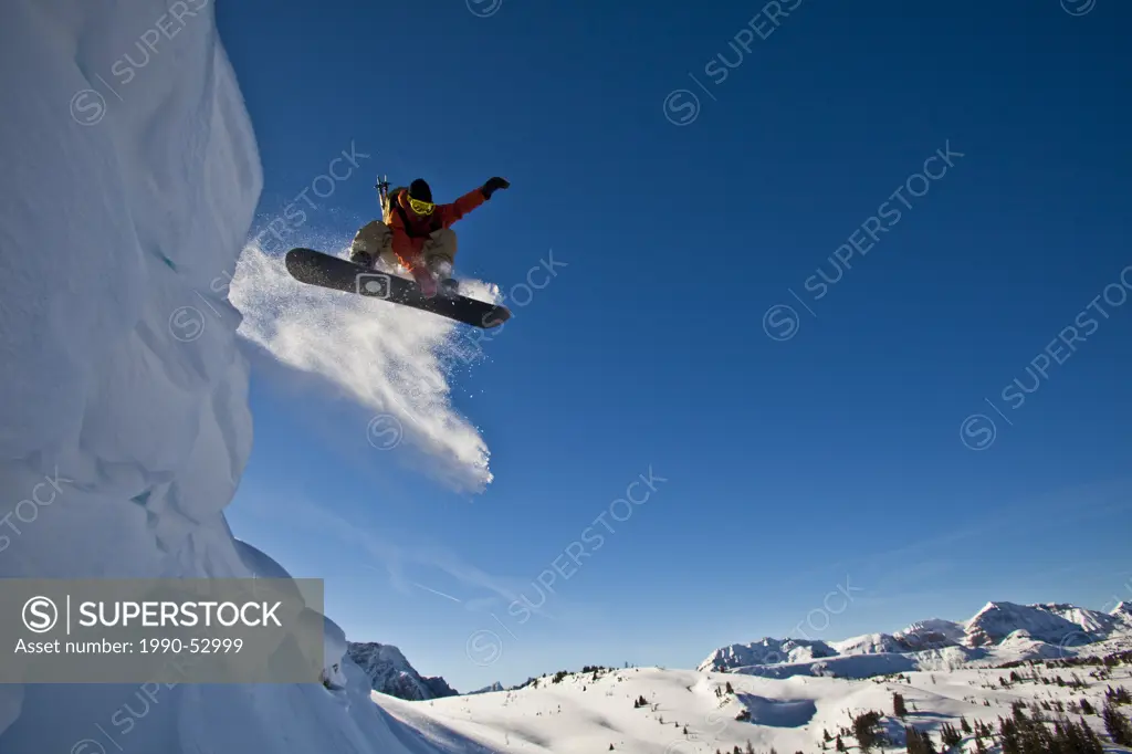 A backcountry snowboarder launches a cornice, Healy Pass, Banff National Park, Alberta, Canada