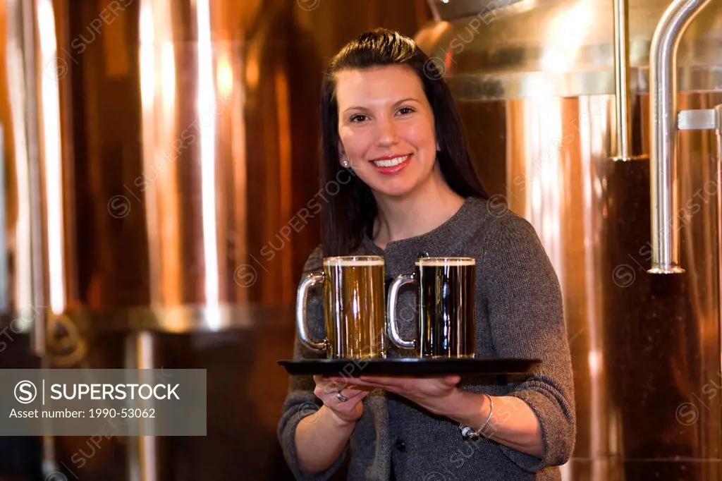Brew Pub manager displays two popular beer produced at the Village Pub and Restaurant, brew pub in Campbell River. Campbell River, Vancouver Island, B...