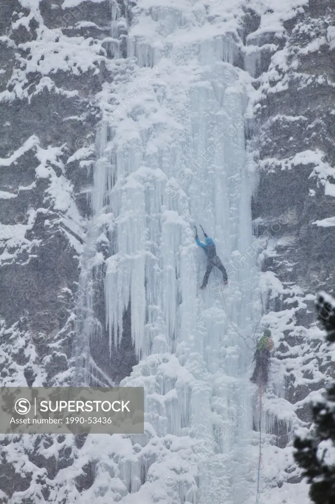 Two female ice climbers ascend the multi_pitch ice route, Moonlight WI4, Even Thomas Creek, Kananaskis, Alberta, Canada