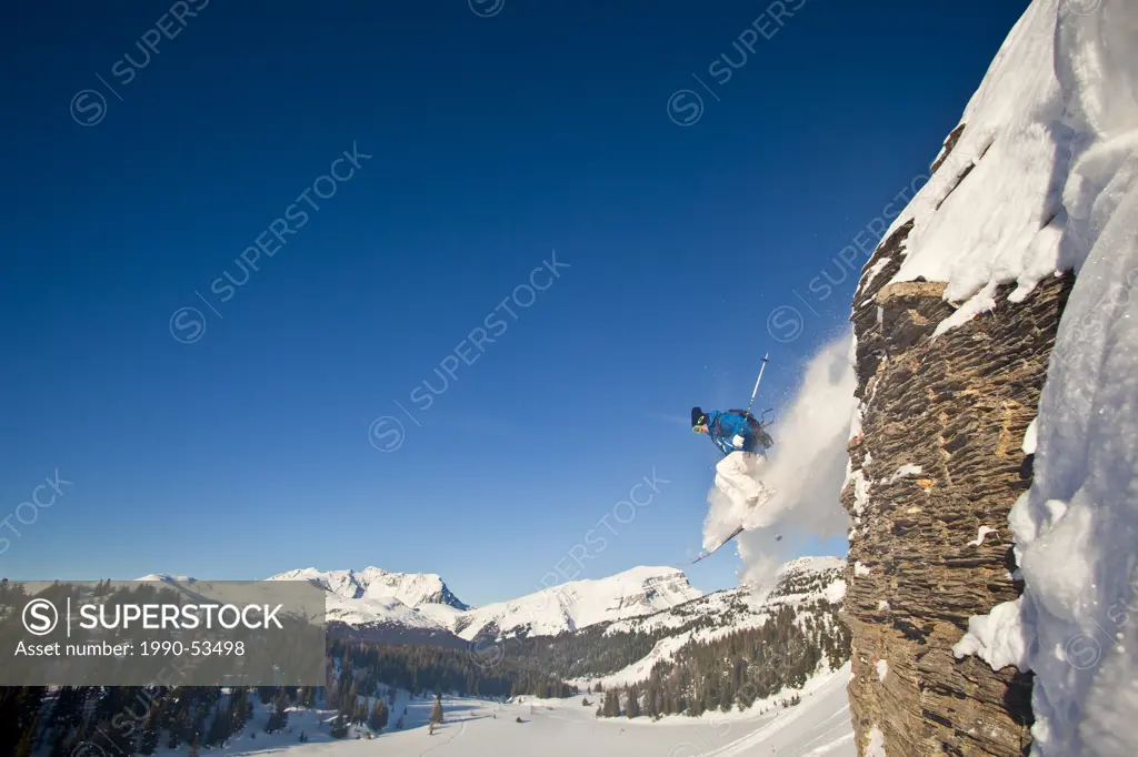 A young male skier catches off a cliff in Banff National Park, Alberta, Canada