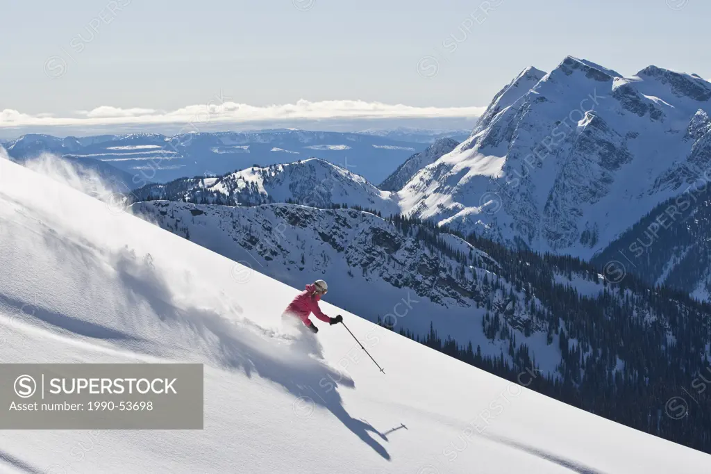 Young woman skiing untracked powder at Mustang Powder Catskiing, British Columbia, Canada.