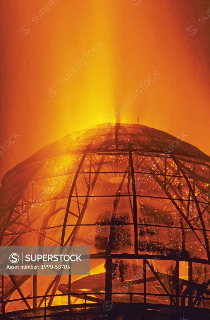 Beehive burner operating at sawmill at night, Smithers, British Columbia, Canada.