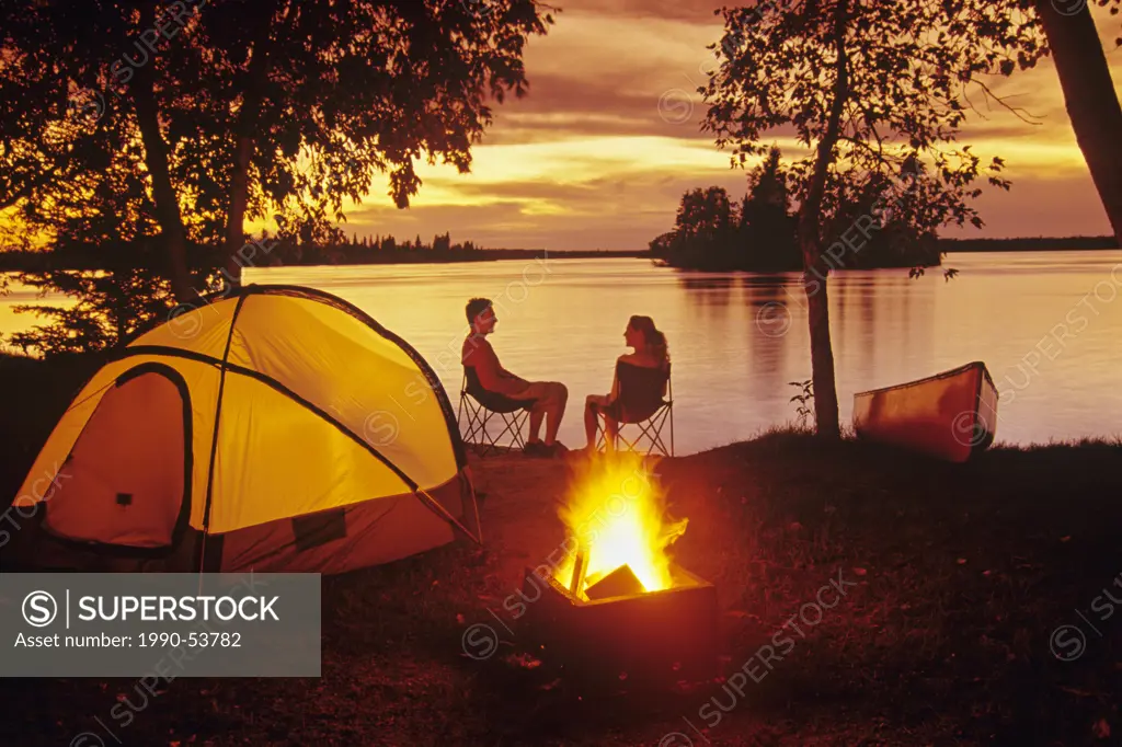 Young couple camping, Otter Falls, Whiteshell Provincial Park, Manitoba, Canada.