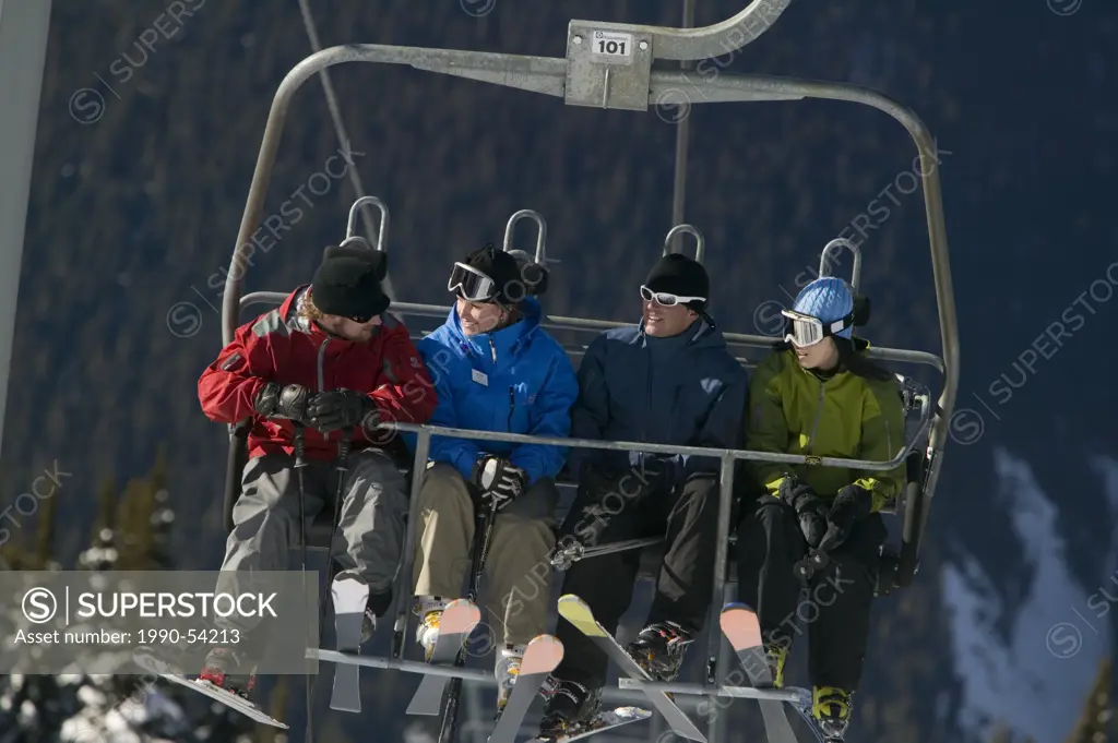 Four skiers riding the chairlift, Whistler, British Columbia, Canada.