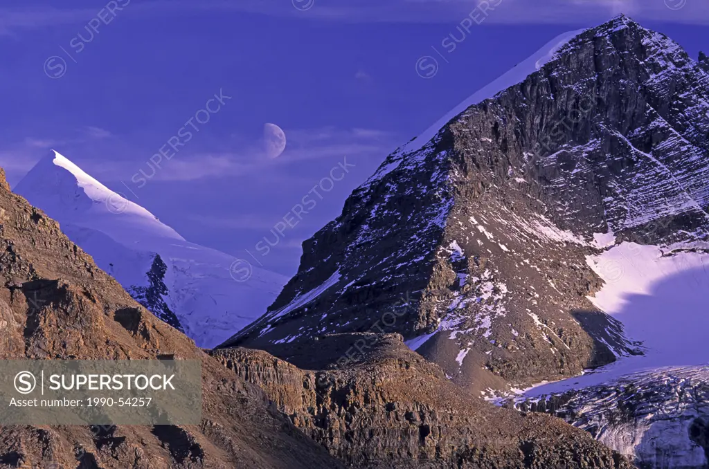 Half moon rising over Resplendent Mountain 3426 m, framed by the valley between Rearguard Mountain L and Mount Waffle R, Mount Robson Provincial Park,...