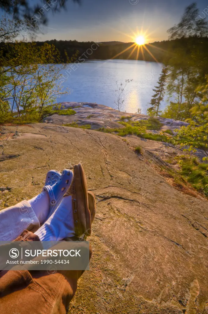 Couple enjoying a sunset over George Lake in Killarney Provincial Park, Ontario, Canada