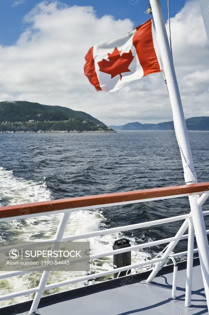 Canadian flag on the stern of a boat, Saguenay River, Pointe_Noire in Baie_Sainte_Catherine, Charlevoix, Quebec, Canada