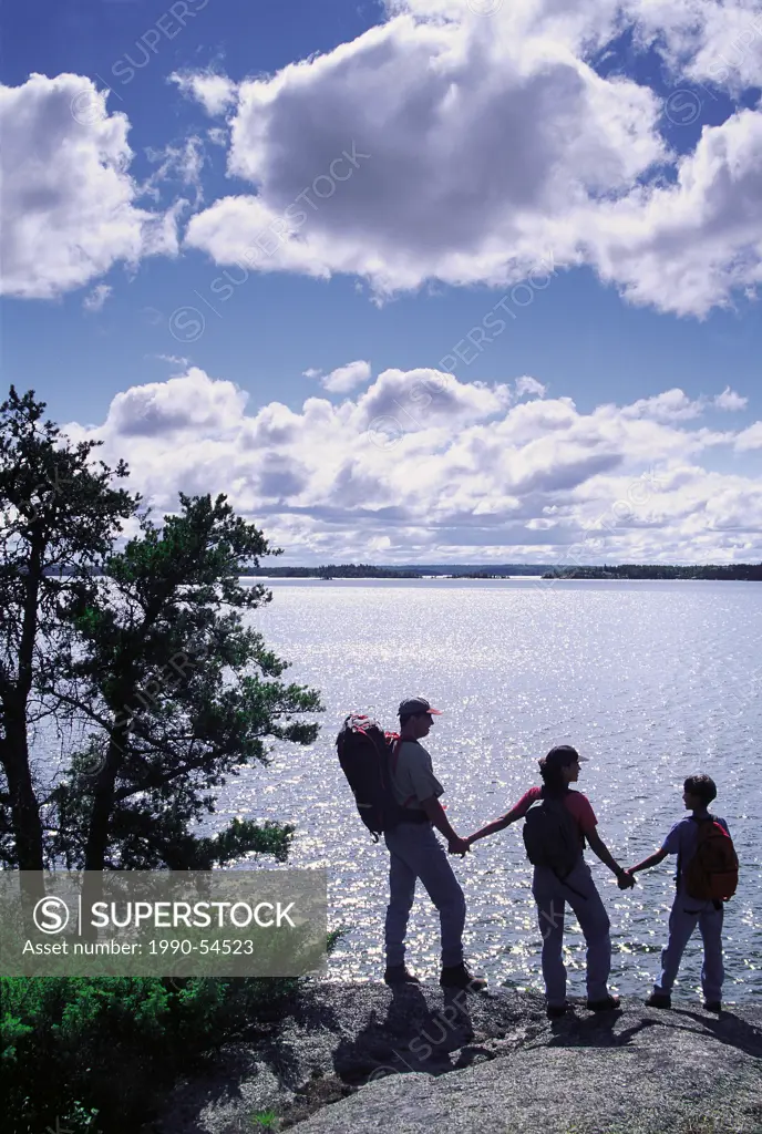 Family hiking along cliff enjoying the view, Big Whiteshell Lake, Whiteshell Provincial Park, Manitoba, Canada