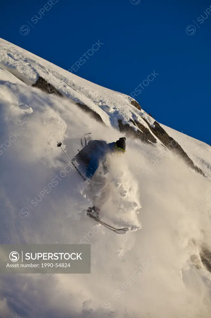 A young male skier catches off a cliff in Banff National Park, Alberta, Canada