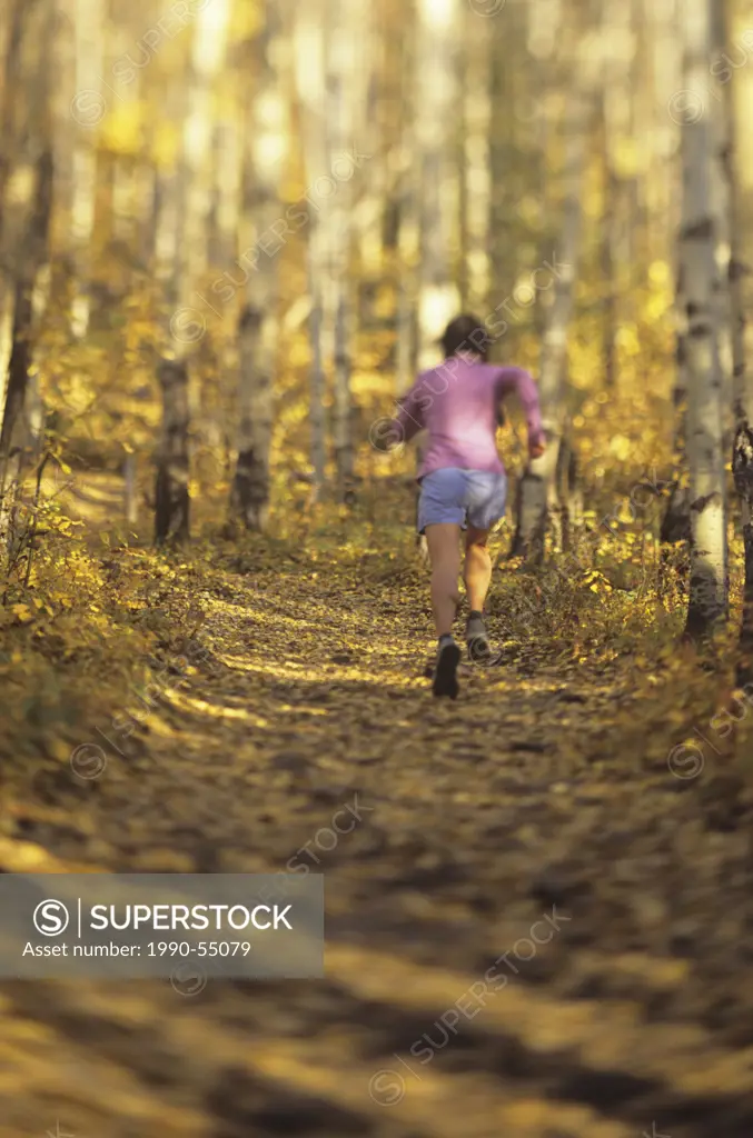 Woman trail running, Yamnuska, Alberta, Canada.