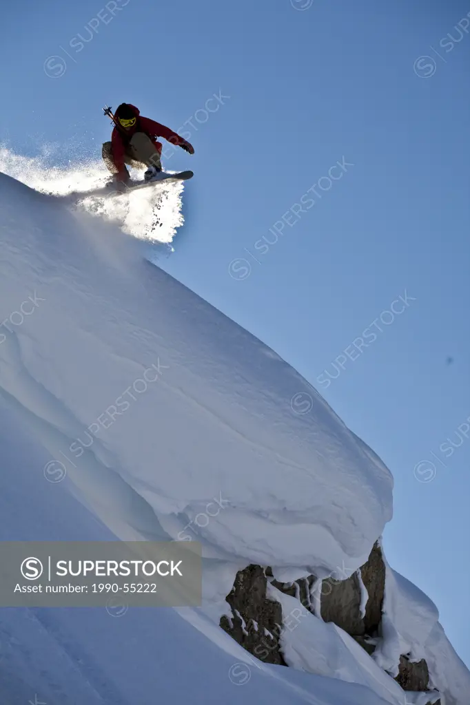 A backcountry snowboarder launches a cornice, Healy Pass, Banff National Park, Alberta, Canada