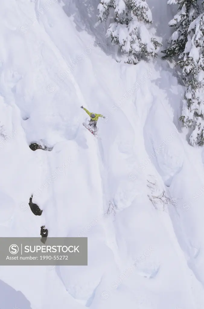 A snowboarder taking a massive jump off the pillows at Shames Mountain, Terrace, British Columbia, Canada