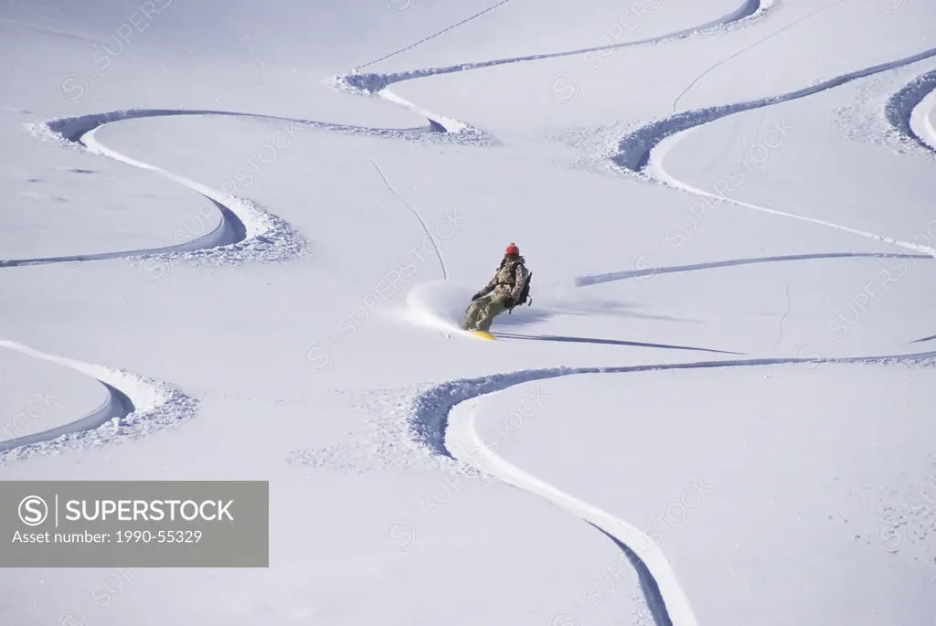 young female backcountry snowboarding in Golden, British Columbia, Canada.