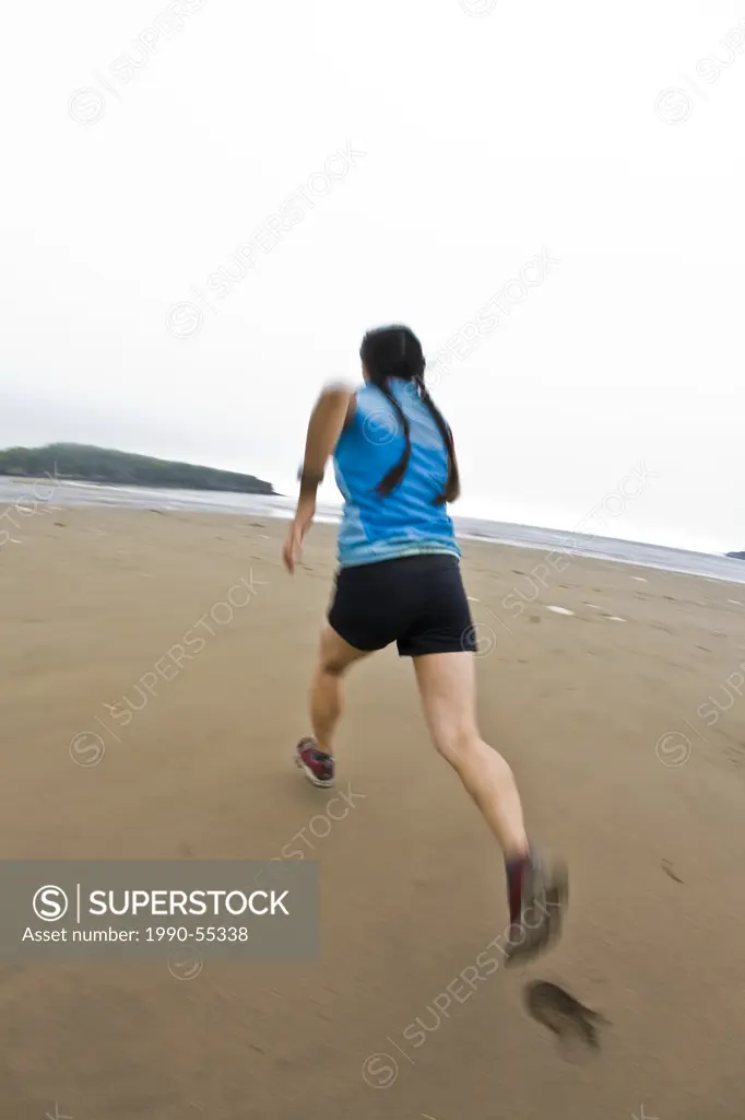 A young female running along the shores of the beach at Mispec Park, Saint John, New Brunswick, Canada.
