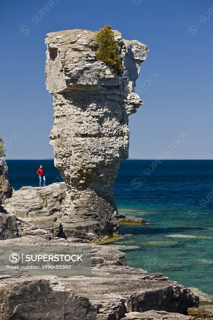 Person next to sea stack along the shoreline of Flowerpot Island in the Fathom Five National Marine Park, Lake Huron, Ontario, Canada