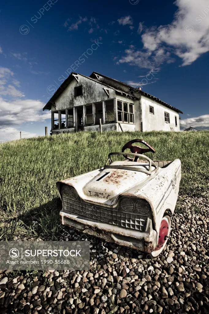 Abandoned farmhouse with child´s pedal car, Saskatchewan, Canada