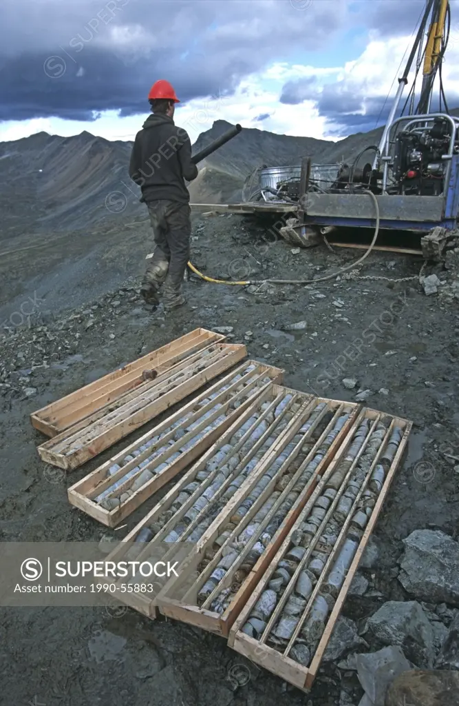 Drill rig operator taking drill pipe back to rig, Yukon Territory, Canada