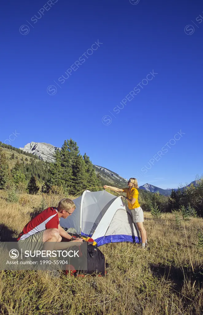 Couple setting up camp in the Canadian Rockies, Alberta, Canada.