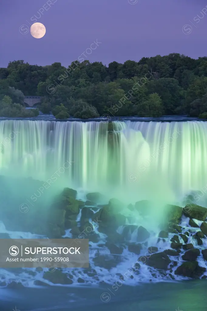 The American Falls with Full moon at dusk lit with lights photographed from Niagara Falls, Ontario, Canada.
