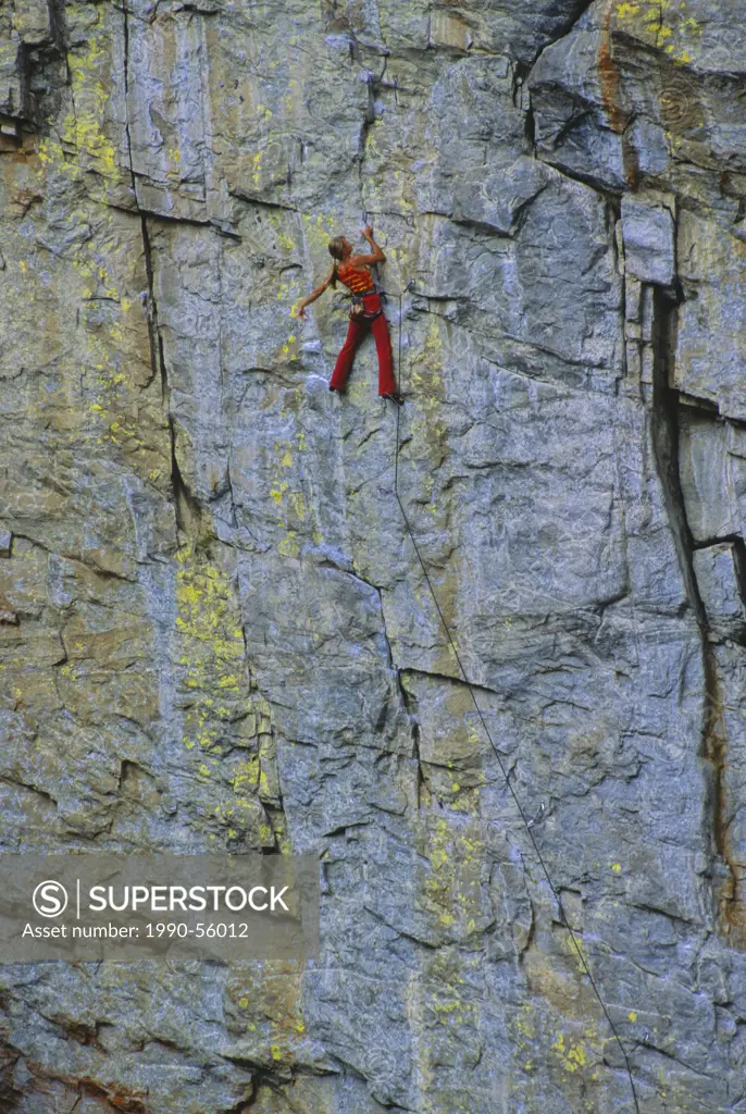 Female rock climber, Julie Leino, climbing The Bottom Line 5.11a on Tottering Pillar Wall, the Grand Canyon, Skaha Bluffs, Penticton, British Columbia...