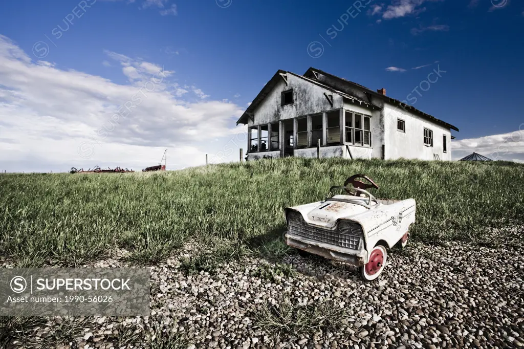 Abandoned farmhouse with child´s pedal car, Saskatchewan, Canada