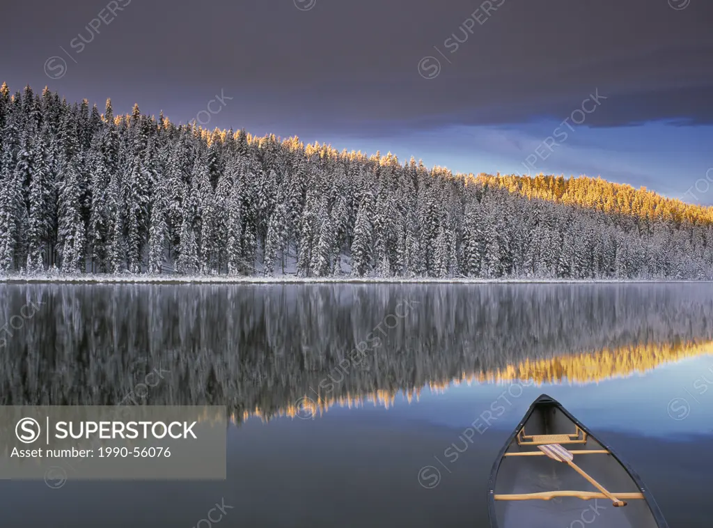 Canoe on Winchell Lake after first snowfall, Alberta, Canada.