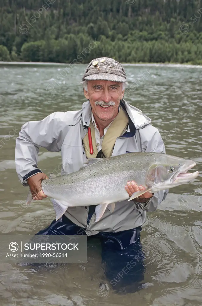 Flyfisherman holding steelhead prior to release, Dean river, British Columbia, Canada.