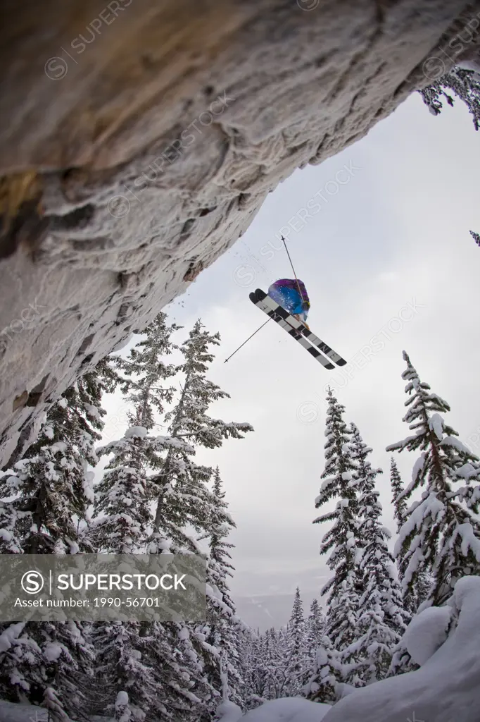 A young male skier drops a big cliff at Kicking Horse Resort, Golden, Britsh Columbia, Canada