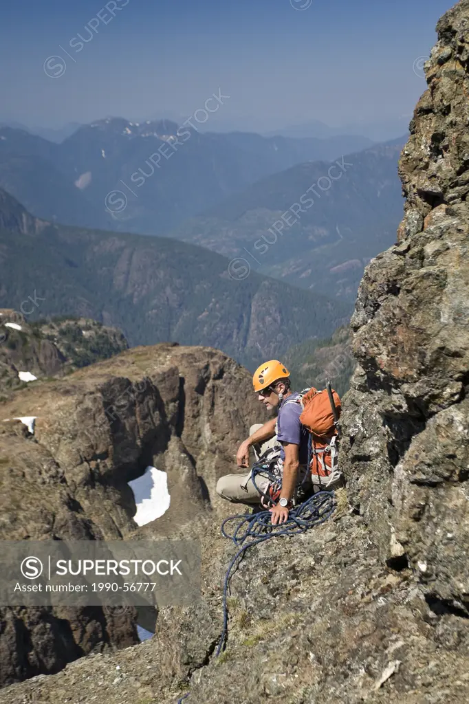 A climber takes a break and waits for fellow climbers to catch up to him while ascending Elkhorn Mountain in Strathcona Park, Vancouver Island, Britis...