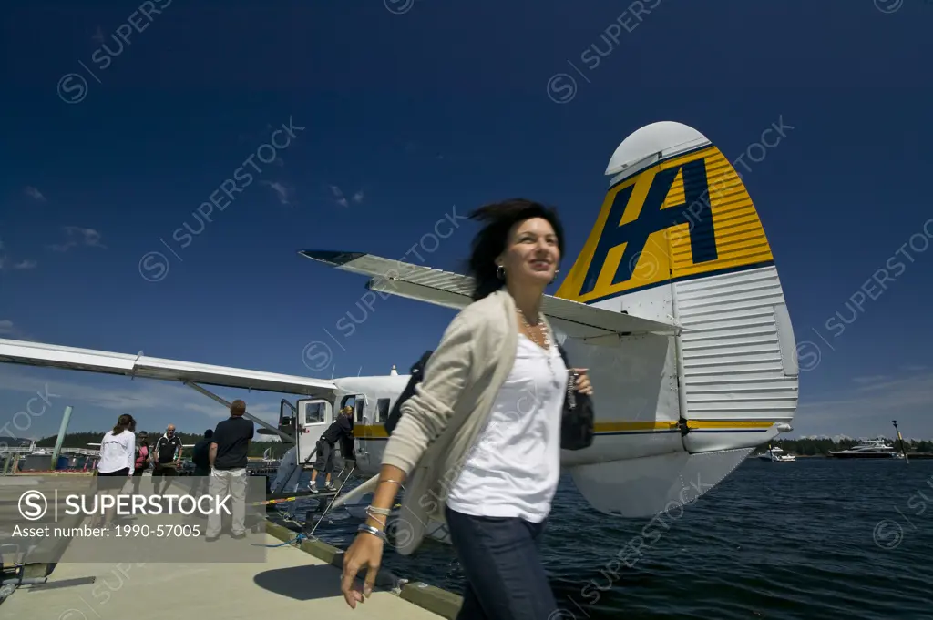 A young woman arrives in Nanaimo via Harbour Air´s scheduled flight operation on Nanaimo´s waterfront. Nanaimo, Central Vancouver Island, British Colu...
